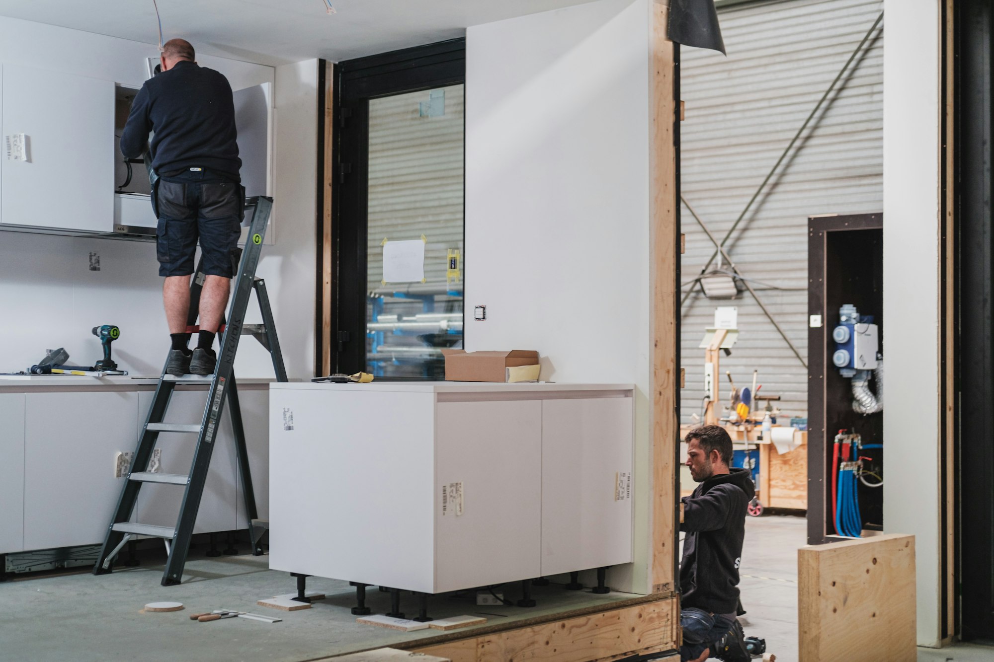 Bouwvakkers werken aan de keuken van een prefab houtskeletbouw module