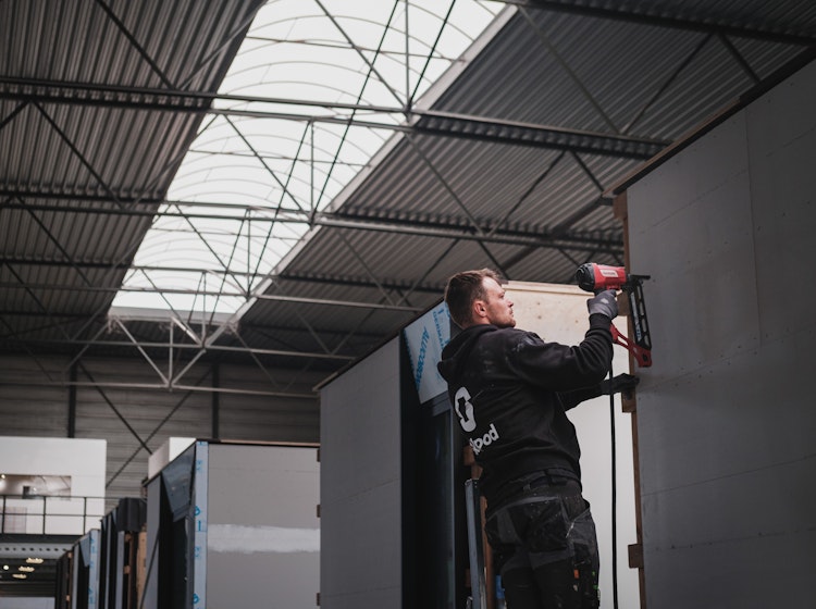 Bouwvakker werkt aan een prefab houtskeletbouw woning