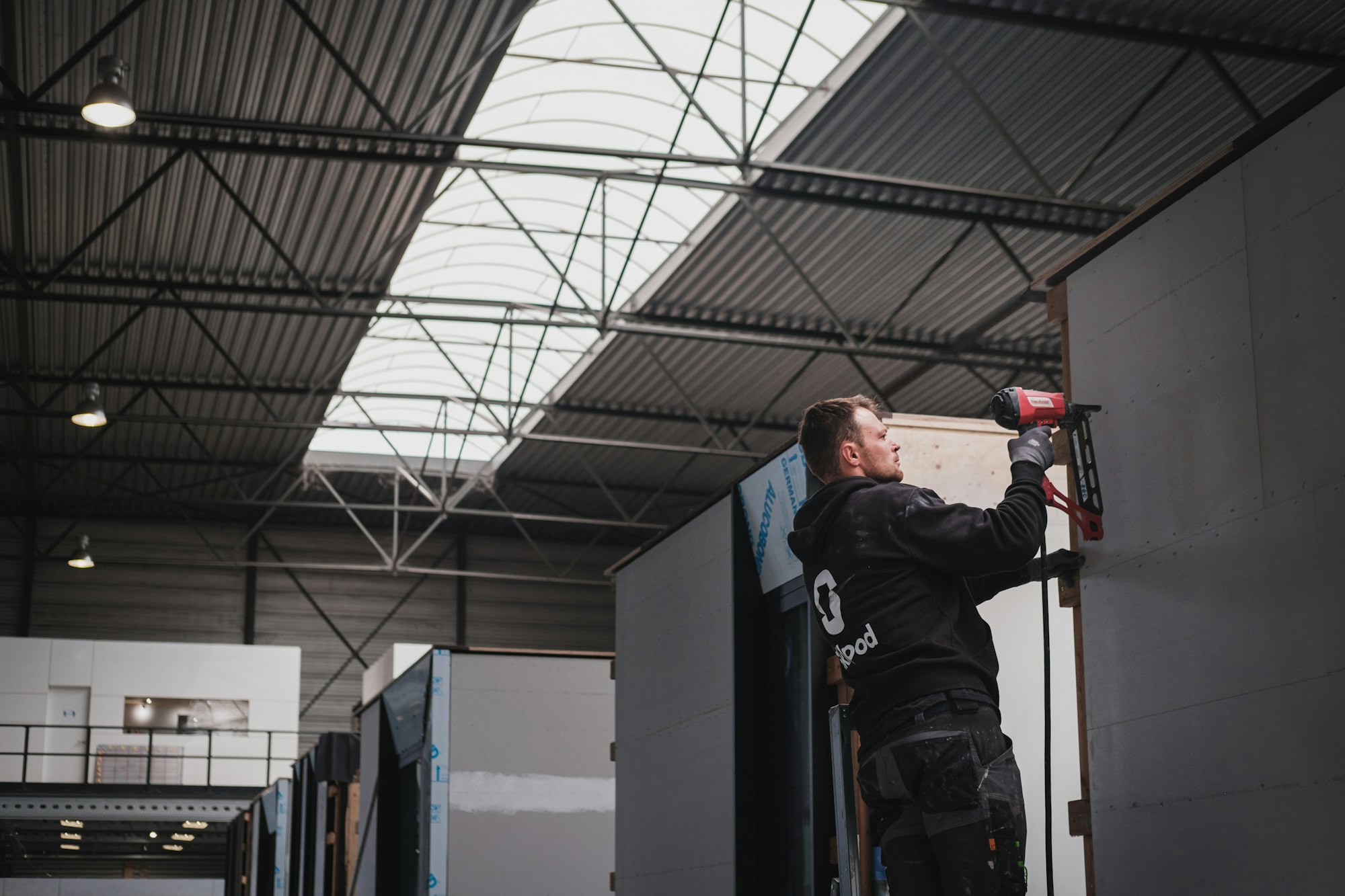 Bouwvakker werkt aan een prefab houtskeletbouw woning